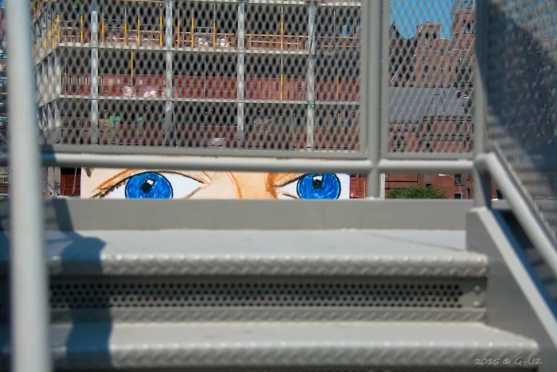Dos ojos pintados asoman entre escalones.