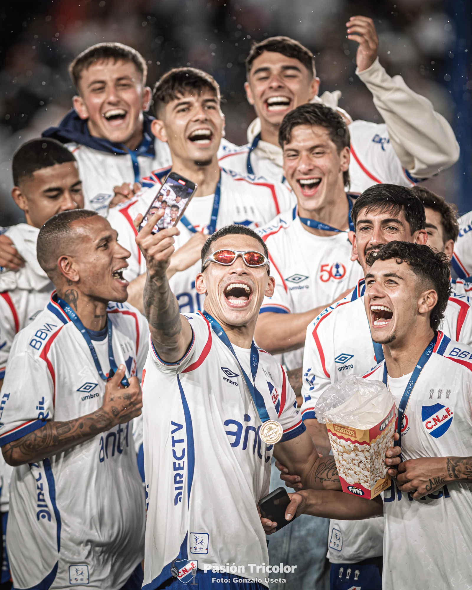 Un grupo de jugadores celebra reunido junto al trofeo.
