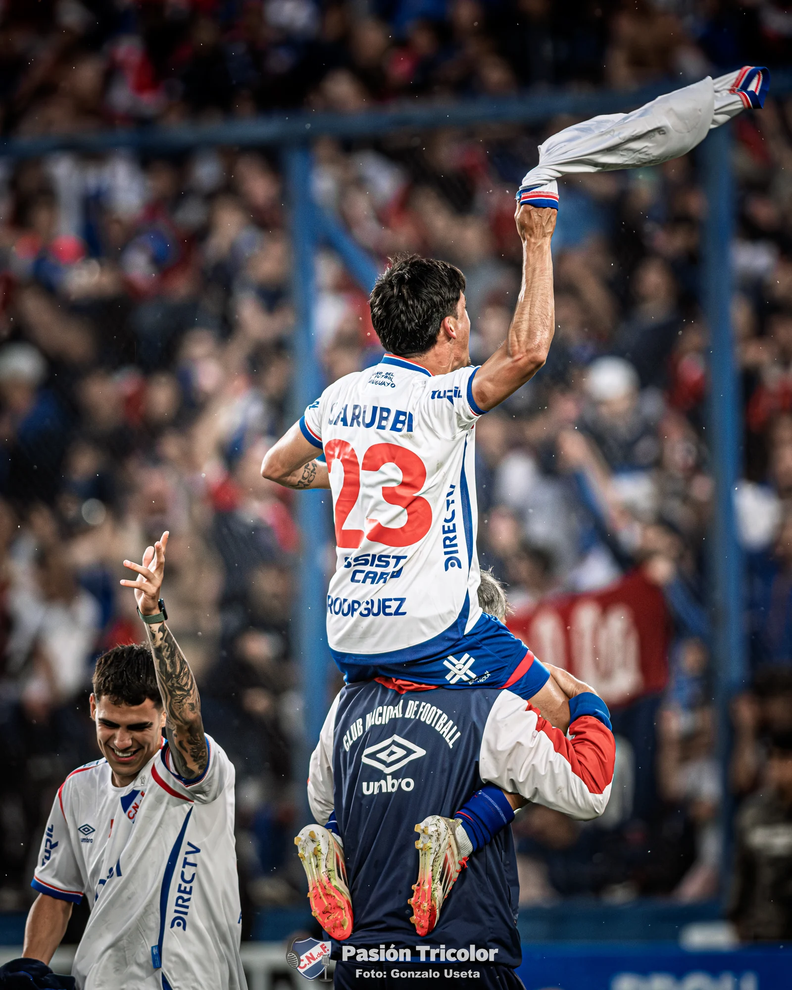 Un jugador de Nacional festeja sobre los hombros de un compañero.
