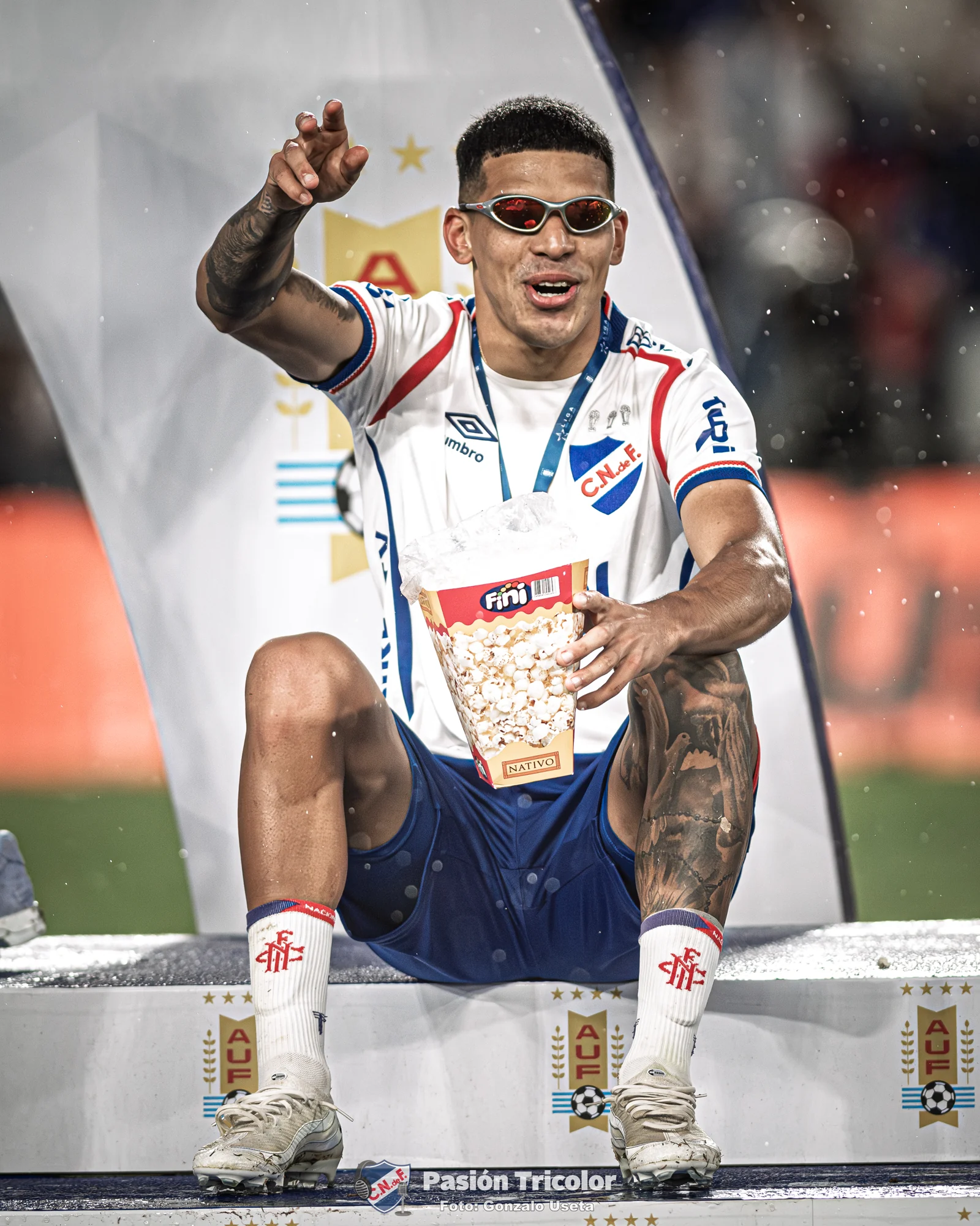 Un jugador con medalla saluda sentado durante la celebración.