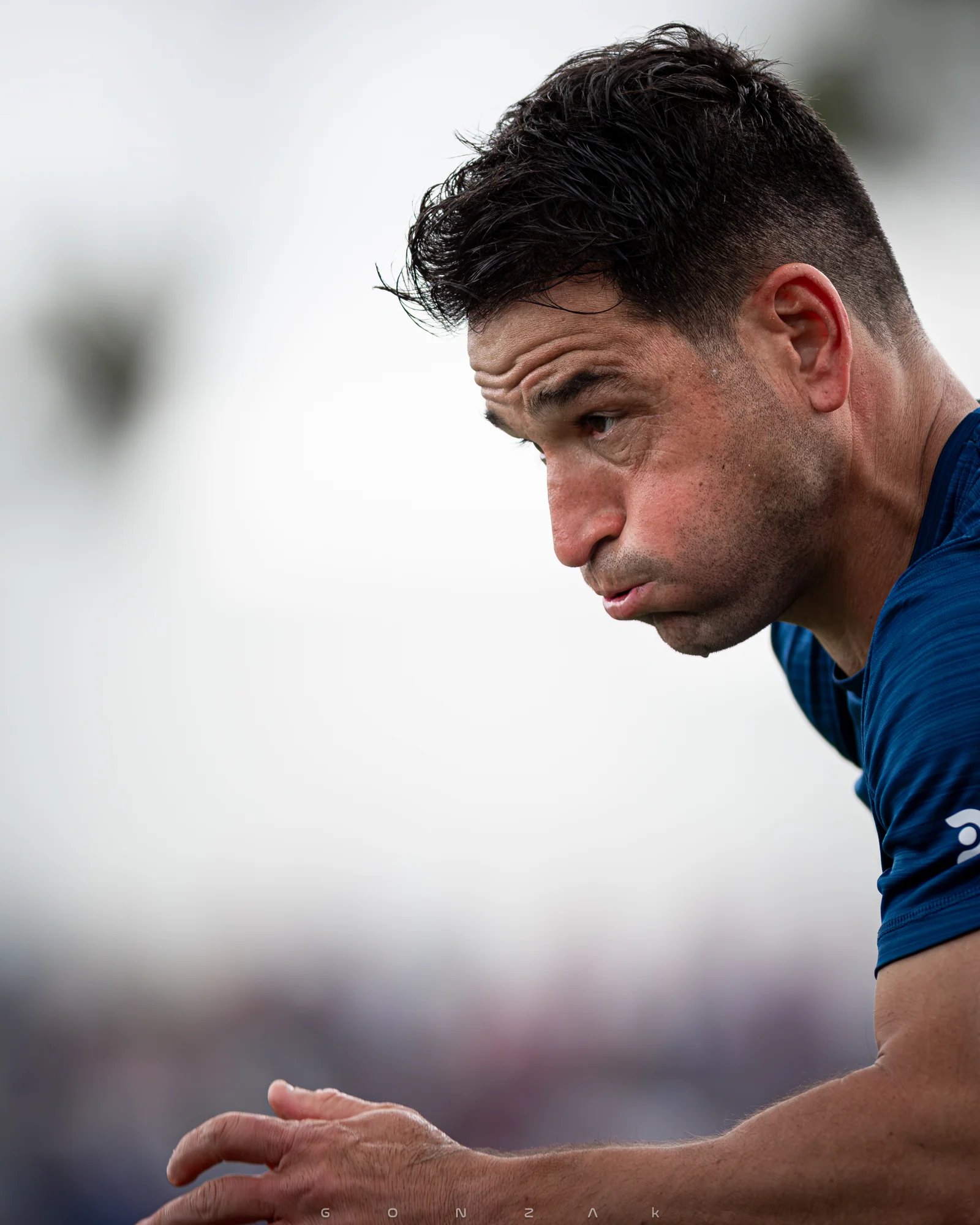 Retrato de perfil de un deportista inclinado hacia adelante.