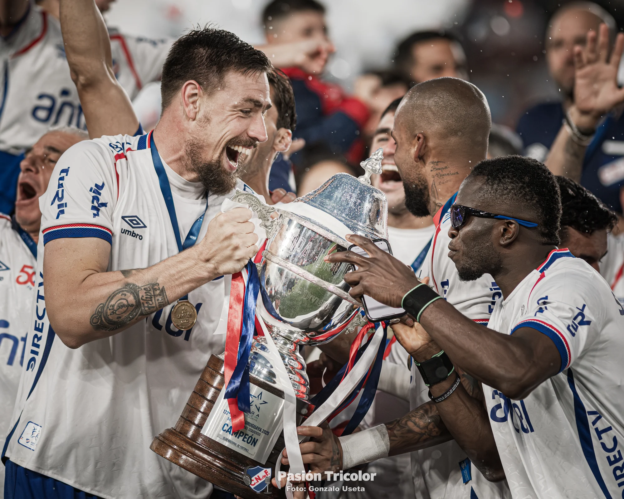 Jugadores de Nacional celebran juntos con un trofeo.